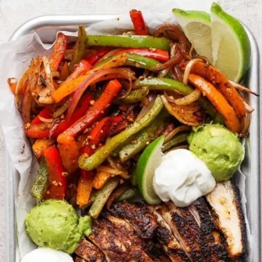 Blackstone chicken fajitas sizzling on the grill with colorful vegetables