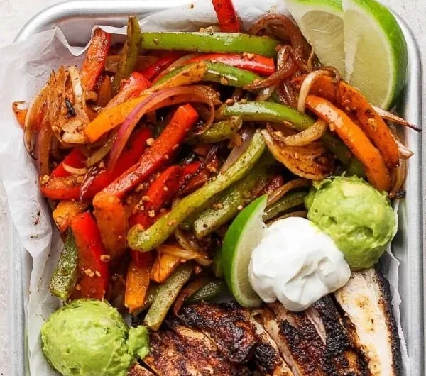 Blackstone chicken fajitas sizzling on the grill with colorful vegetables