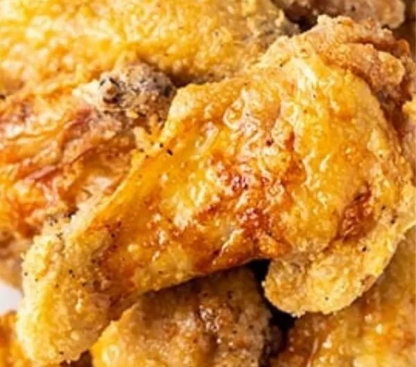 Crispy air fryer chicken wings garnished with herbs and served in a bowl