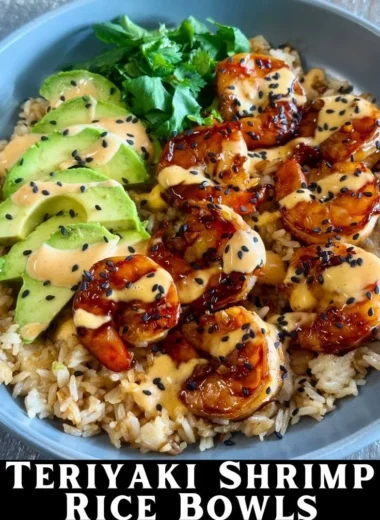 Delicious teriyaki shrimp rice bowl garnished with vegetables and sesame seeds.