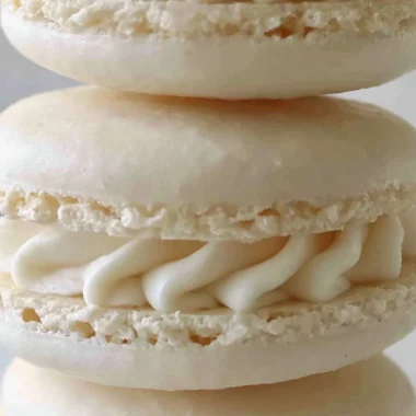 Plate of colorful aquafaba vegan macarons arranged beautifully.