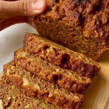 Moist and delicious best zucchini bread loaf on a wooden table.