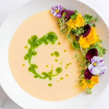 Chilled peach soup served in a bowl garnished with fresh mint leaves.