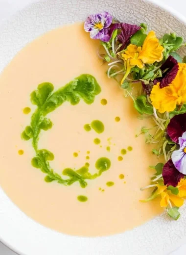 Chilled peach soup served in a bowl garnished with fresh mint leaves.