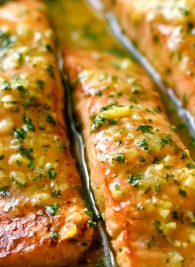 Delicious Garlic Butter Salmon topped with herbs and lemon slices