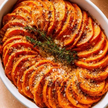 Bowl of Garlic Parmesan Roasted Sweet Potatoes topped with fresh herbs