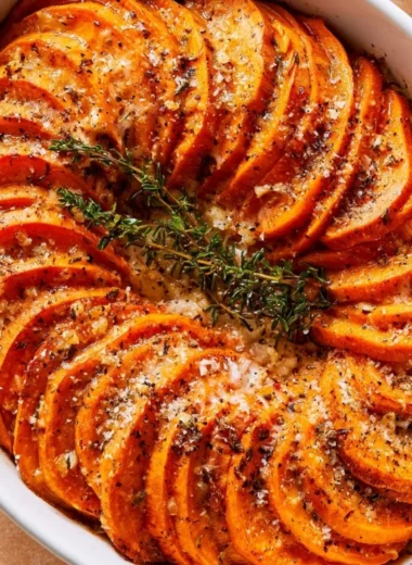 Bowl of Garlic Parmesan Roasted Sweet Potatoes topped with fresh herbs