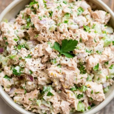 Healthy tuna salad with fresh vegetables and dressing on a plate