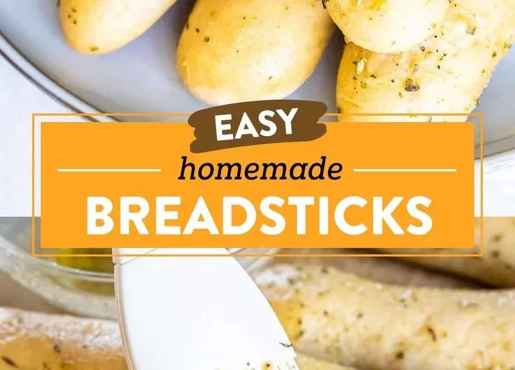 Plate of homemade garlic herb breadsticks with herbs and garlic butter