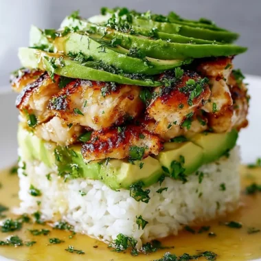 Honey Lime Chicken Avocado Rice Stack garnished with fresh herbs.