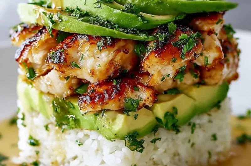 Honey Lime Chicken Avocado Rice Stack garnished with fresh herbs.