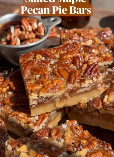 Delicious pecan pie bars topped with pecans and caramel sauce.