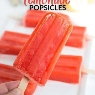 Strawberry lemonade popsicles in a colorful summer setting