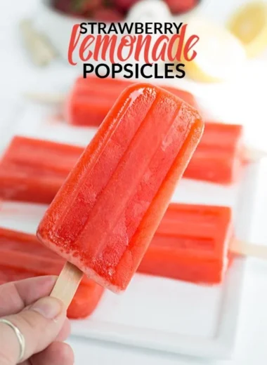 Strawberry lemonade popsicles in a colorful summer setting