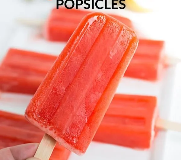 Strawberry lemonade popsicles in a colorful summer setting