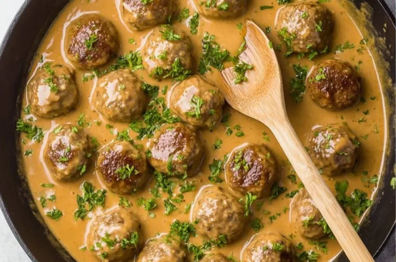 Plate of delicious Swedish meatballs served with creamy sauce and lingonberry jam