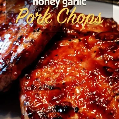 Delicious honey garlic pork chops served on a plate with herbs