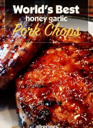 Delicious honey garlic pork chops served on a plate with herbs