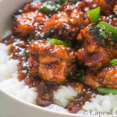 Delicious Mongolian Chicken stir-fry served over rice with vegetables.