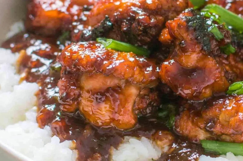 Delicious Mongolian Chicken stir-fry served over rice with vegetables.