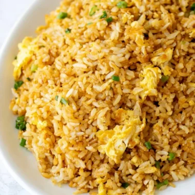 Bowl of cozy easy fried rice garnished with vegetables and herbs