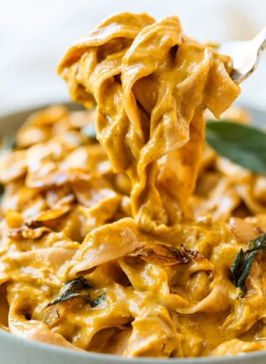 Cozy pumpkin pasta sauce served with pasta and herbs in a bowl