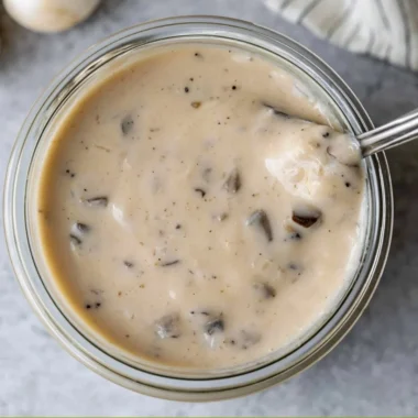 A bowl of homemade cream of mushroom soup garnished with herbs