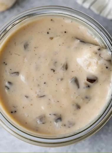 A bowl of homemade cream of mushroom soup garnished with herbs