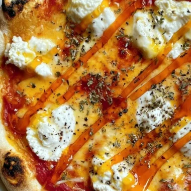Delicious hot honey ricotta pizza with drizzled honey and fresh herbs on top.