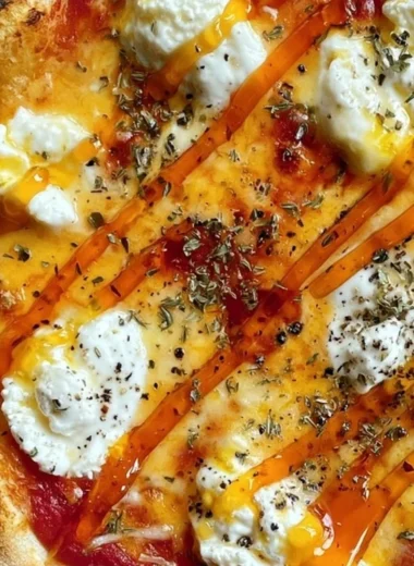 Delicious hot honey ricotta pizza with drizzled honey and fresh herbs on top.