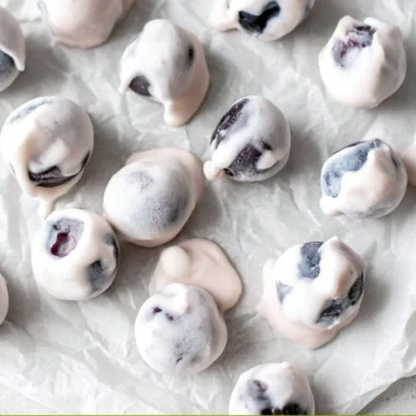 A bowl of yogurt covered blueberries, a healthy and sweet snack option.