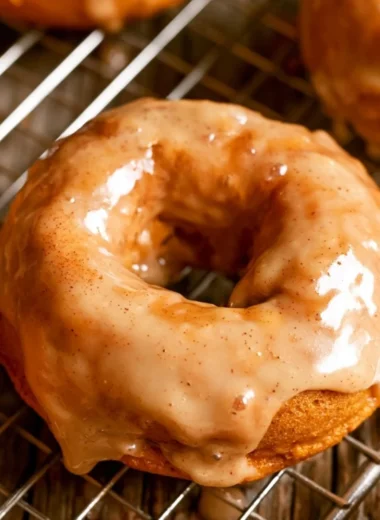Cozy vegan pumpkin donuts served on a plate, topped with spices and icing.