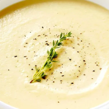 Bowl of creamy cauliflower soup topped with fresh herbs