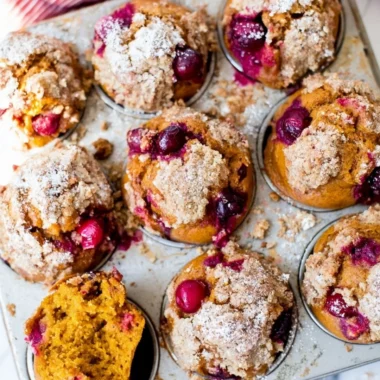 Pumpkin Spice Cranberry Muffins displayed on a rustic wooden table.